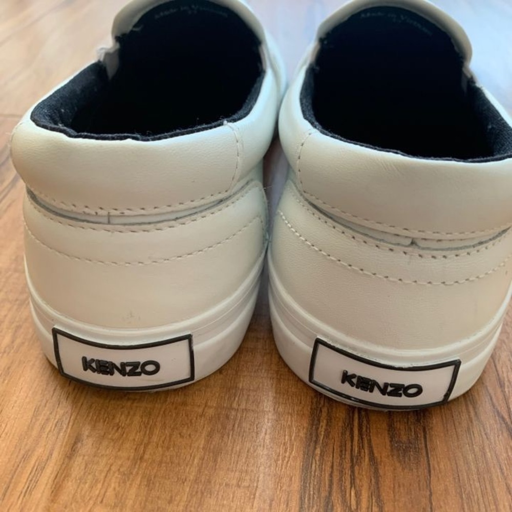 Low-top leather slip-on sneakers in white.
